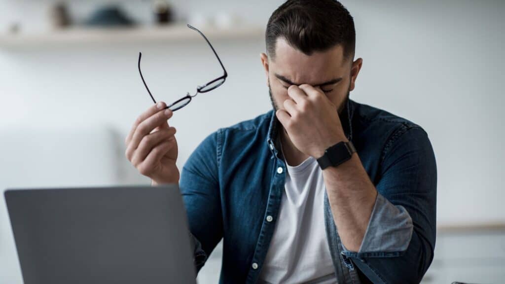 Male at desk looking tired and stressed